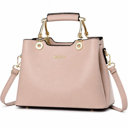 Blush pink vegan leather structured satchel handbag with gold hardware and top handle, featuring a crossbody strap for women.
